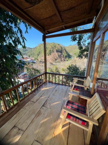 a deck with benches and a view of the mountains at MAMA's House Mộc Châu in Mộc Châu