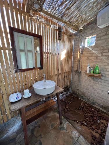 a bathroom with a sink on a wooden wall at MAMA's House Mộc Châu in Mộc Châu