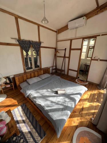 a large bed in a room with wooden floors at MAMA's House Mộc Châu in Mộc Châu