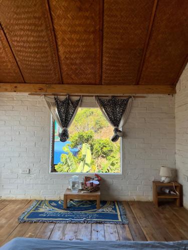 a room with a window with a table and a rug at MAMA's House Mộc Châu in Mộc Châu