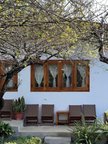 a group of chairs sitting in front of a window at MAMA's House Mộc Châu in Mộc Châu