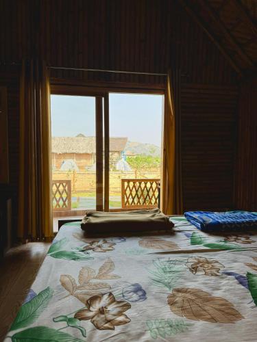a bedroom with a bed with a view of a window at Sunny Guest House Hampi in Hampi