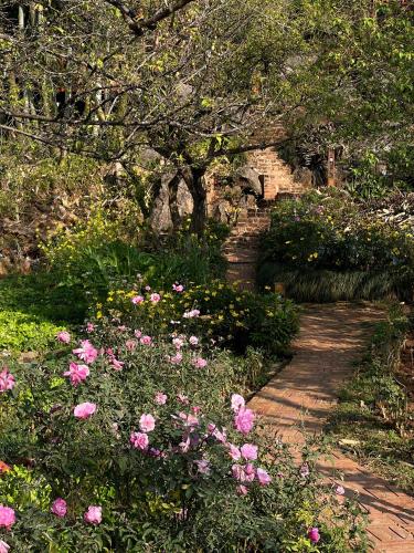 a garden with pink flowers and a stone path at MAMA's House Mộc Châu in Mộc Châu