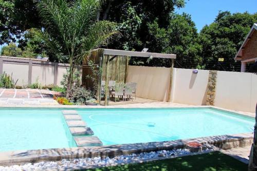 a large swimming pool in a backyard with a fence at Pool house in Polokwane