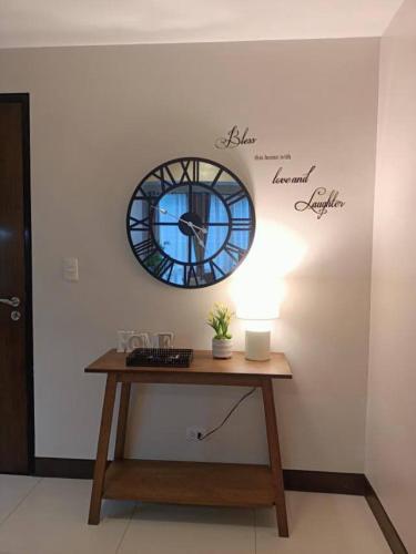 a table with a clock on a wall with a window at Mactan Newtown in Lapu Lapu City