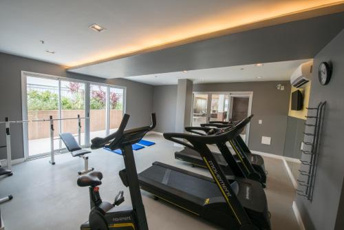 a gym with several treadmills and a row of exercise bikes at Promenade Fusion Itaguaí in Itaguaí