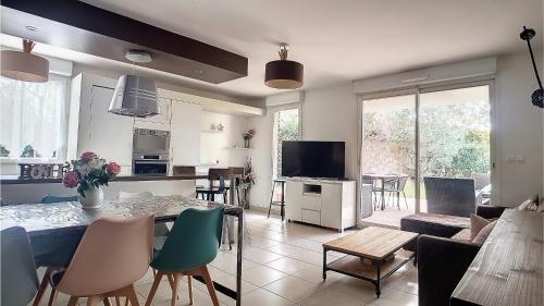 une cuisine et un salon avec une table et des chaises dans l'établissement Appartement 7 personnes jardin et piscine, à La Ciotat