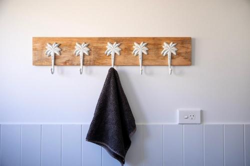 a towel hanging on a wall in a bathroom at Seaside apartment, 100m to beach in Narrabeen