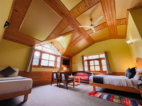 a bedroom with two beds and a wooden ceiling at Hotel Hollywood Vibes #riverview #premium rooms #prime location #most awarded #parking #top rated #open terrace #lawn #best selling hotel in manali in Manāli