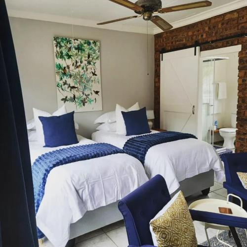 a bedroom with two beds with blue and white sheets at Den-Away Guesthouse Self Catering Middelburg Mpumalanga in Mhluzi