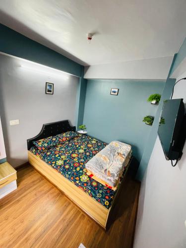 a bedroom with a bed with a colorful comforter at Blue Valley Apartment in Darjeeling