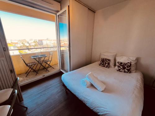 - une petite chambre avec un lit et une grande fenêtre dans l'établissement Terrasse du soleil, Studio proche Gare Montpellier, à Montpellier