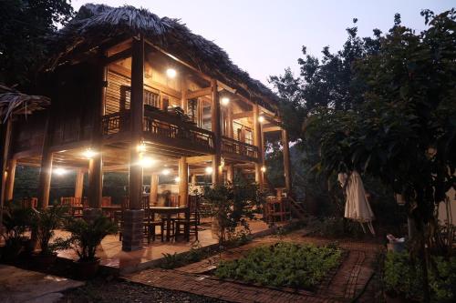 a house with a table and chairs in front of it at MAMA's House Mộc Châu in Mộc Châu