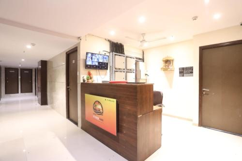 a lobby of a building with a tv on the wall at Sunrise cave in Surat