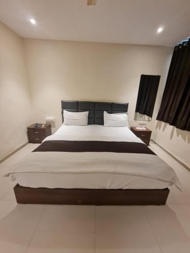 a bedroom with a large bed and two night stands at Sunrise cave in Surat