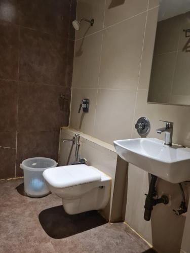 a bathroom with a toilet and a sink at Sunrise cave in Surat