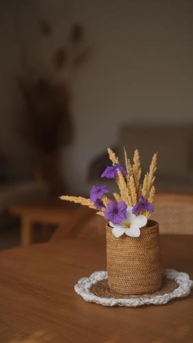 a small vase with purple and white flowers on a table at AMAN Villas & SPA in Gili Air