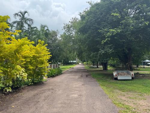 a dirt road in a park with trees at Darwin Boomerang Motel and Caravan Park in Howard Springs