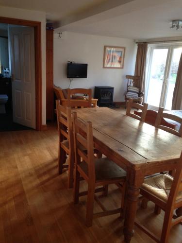 a dining room with a wooden table and chairs at Rebels Hide -Self check in rooms in Penrith