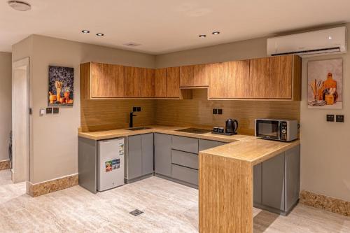 a kitchen with wooden cabinets and a counter top at Medad Apartments Al Hamra in Al Khobar
