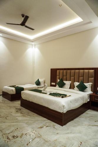 a bedroom with two beds and a ceiling at Hotel Ratan Elite in Bijainagar