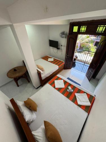 a small room with two beds and a balcony at Ella RV Heaven World Hotel in Ella