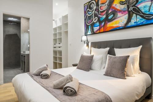 une chambre avec un grand lit blanc avec des oreillers dans l'établissement La Galerie 58 - Luxe & Design en centre ville, à Nice