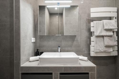 une salle de bain avec un lavabo blanc et un miroir dans l'établissement La Galerie 58 - Luxe & Design en centre ville, à Nice