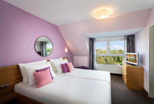 a purple room with a bed and a window at Hotel Uhu Garni - Superior in Cologne