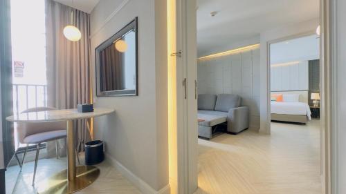 a hotel room with a bedroom and a bed and a table at The Quarter Ploenchit by UHG in Bangkok