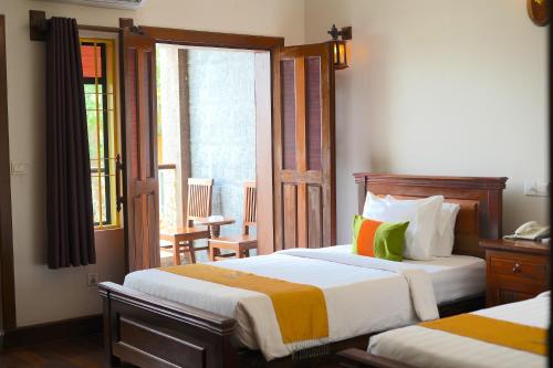 a hotel room with two beds and a balcony at Hello Cambodia Boutique in Siem Reap