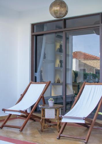 two chairs and a table in a room with a window at Hayce Residence Ocean View Apartment in Kilifi
