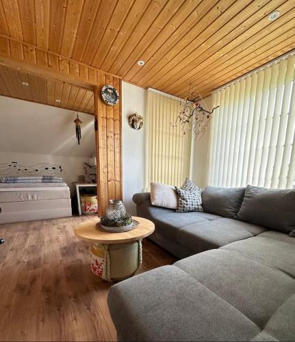a living room with a couch and a table at Privatzimmer bei Renate am Grünen See in Ratingen