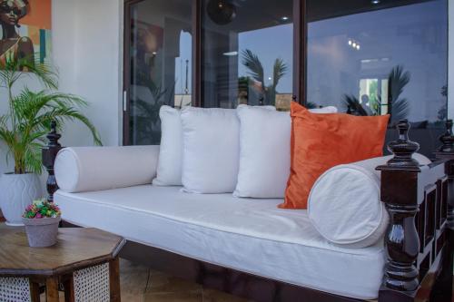 a white couch with pillows on a patio at Hayce Residence Ocean View Apartment in Kilifi