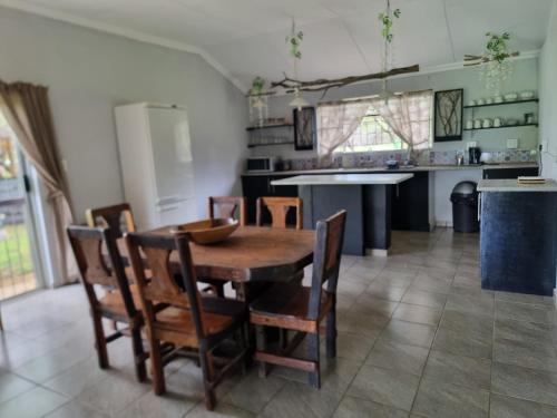 a kitchen with a wooden table and chairs at Ada Selah in Bela-Bela