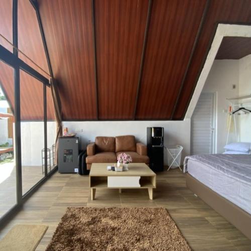 a bedroom with a bed and a couch and a table at Heavenly 2 - Private Triangle in Bandung