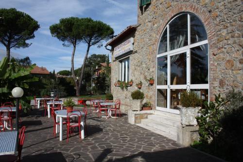 a restaurant with tables and chairs in front of a building at La Palazzina in Chiusdino