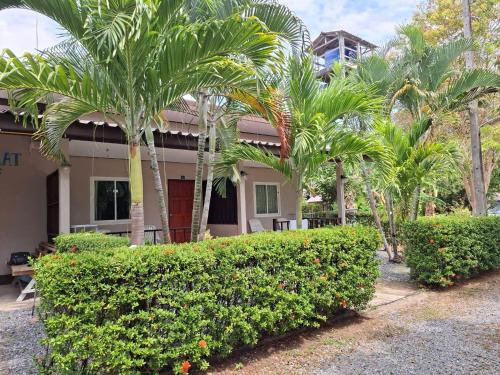 a house with palm trees and bushes in front of it at Lanta Salamat House in Ko Lanta