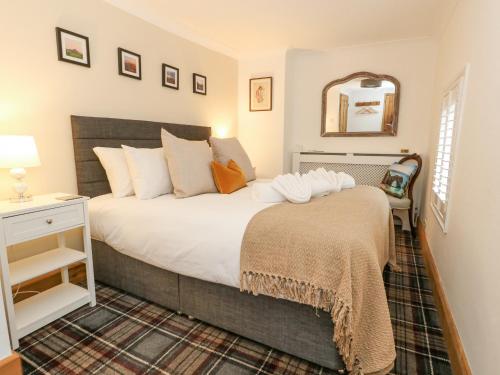 una camera da letto con un letto grande e uno specchio di Miller's Cottage a Dorchester