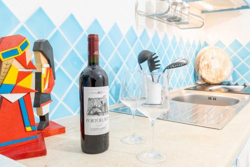 a bottle of wine sitting on a counter next to a glass at Lulamax Sardegna in Budoni