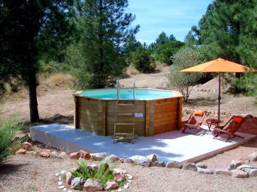 wanna z hydromasażem z parasolem, 2 krzesłami i stołem w obiekcie Villa avec piscine hors sol à 10mn de la plage w mieście Lecci
