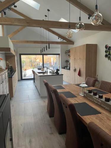 a large kitchen with a table and chairs in it at vakantiewoning Terminus in Beernem