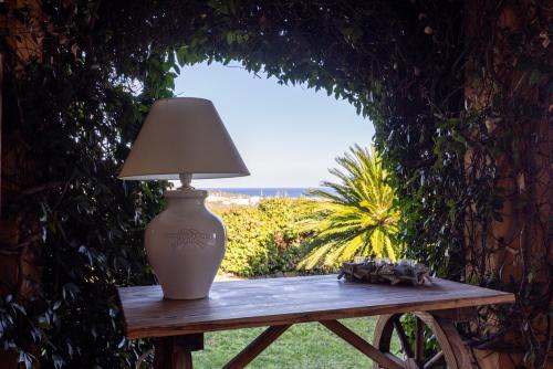 a lamp sitting on a wooden table with a window at Lulamax Sardegna in Budoni