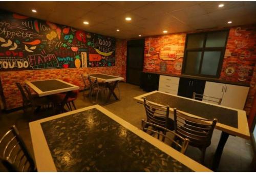 a restaurant with tables and chairs and a wall with graffiti at HOTEL SHYAM INTERNATIONAL - NEAR TERMINAL 3 DELHI AIRPORT WITH - Free AIRPORT PICKUP in New Delhi
