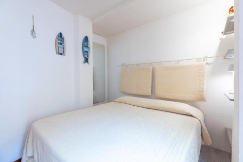 a white bedroom with a white bed in it at Lulamax Sardegna in Budoni