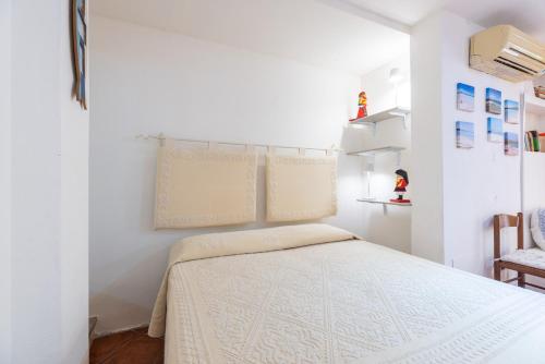 a bedroom with a bed in a white room at Lulamax Sardegna in Budoni