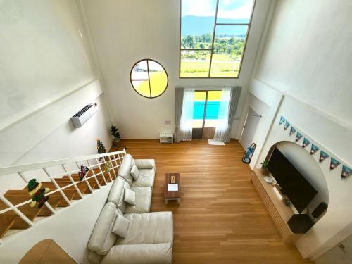 a living room with a couch and a tv at Ada Pool Villa Khaoyai in Pong Talong