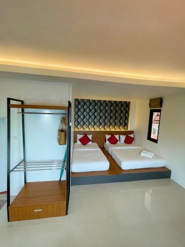 a room with two beds and a glass wall at Vimarn Samed Resort in Ko Samed