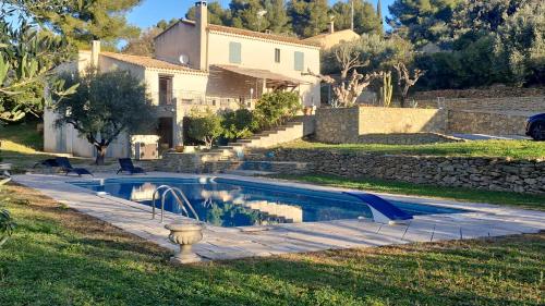 une piscine devant une maison dans l'établissement Maison de Caractère située au coeur des domaines viticoles de BANDOL, à La Cadière-dʼAzur