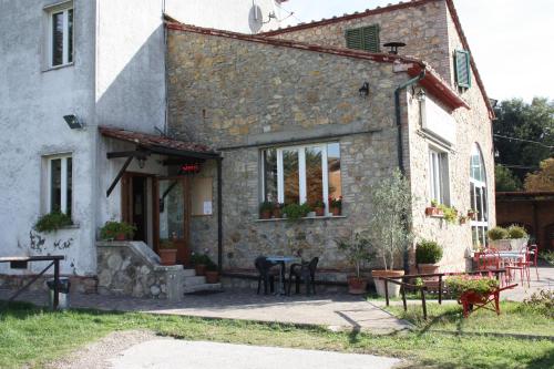 a stone house with a table in front of it at La Palazzina in Chiusdino